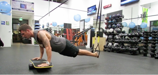 Performing weighted balance exercises on a balance board to improve core strength