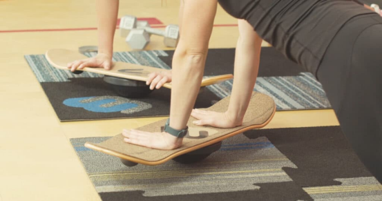 person practicing balance board retention with core engagement