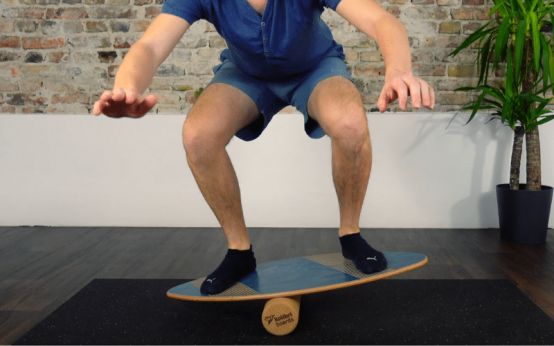 beginner using a balance board with incorrect posture showing training risks