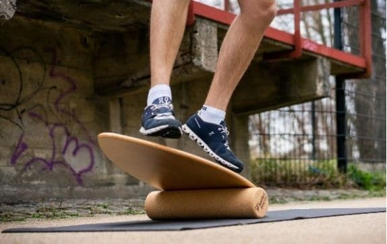 professional athlete performing balance board training for neural reaction