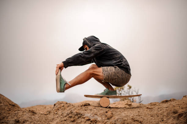 Man balancing on an outdoor balance board.