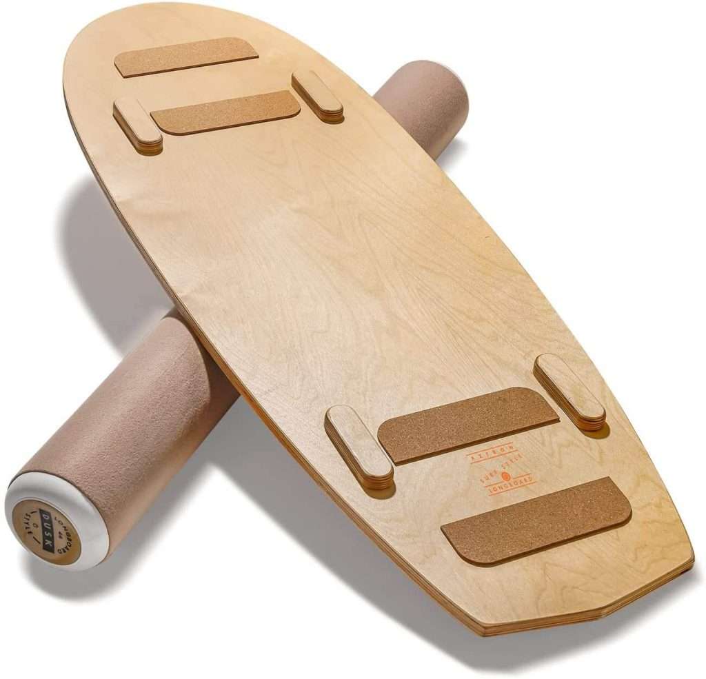 Light wood balance board with cork grips on a beige roller.