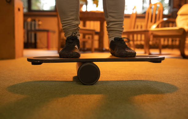 Person's feet on a roller balance board, improving core strength and stability.