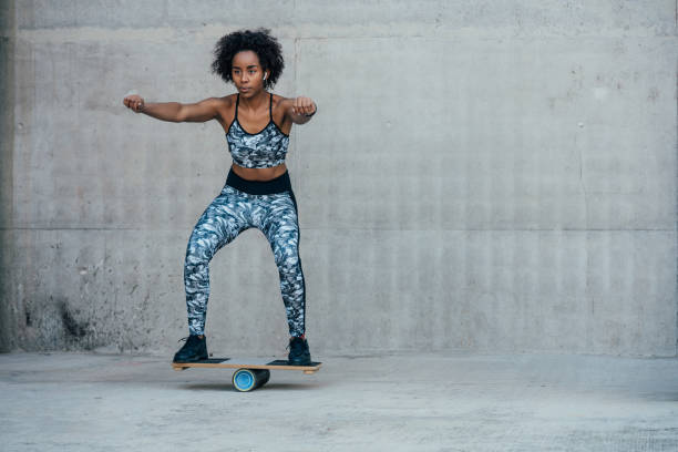 Young woman balancing on a roller balance board, showing athletic skill.