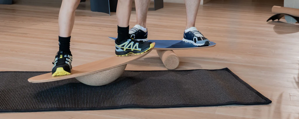 Two pairs of feet on different types of balance board for core training.