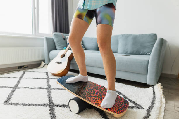 Person practicing balance on a balance board indoors.