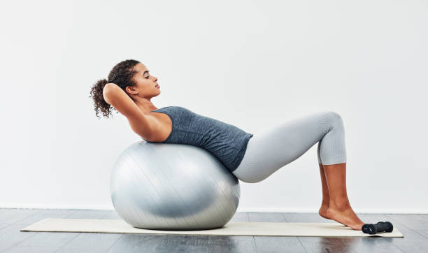 Woman exercising core on a stability ball, improving balance like a balance board.