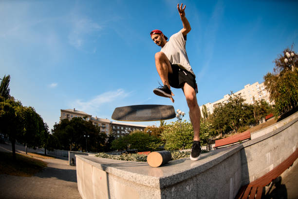 Man performing an aerial trick with a balance board in an outdoor park.