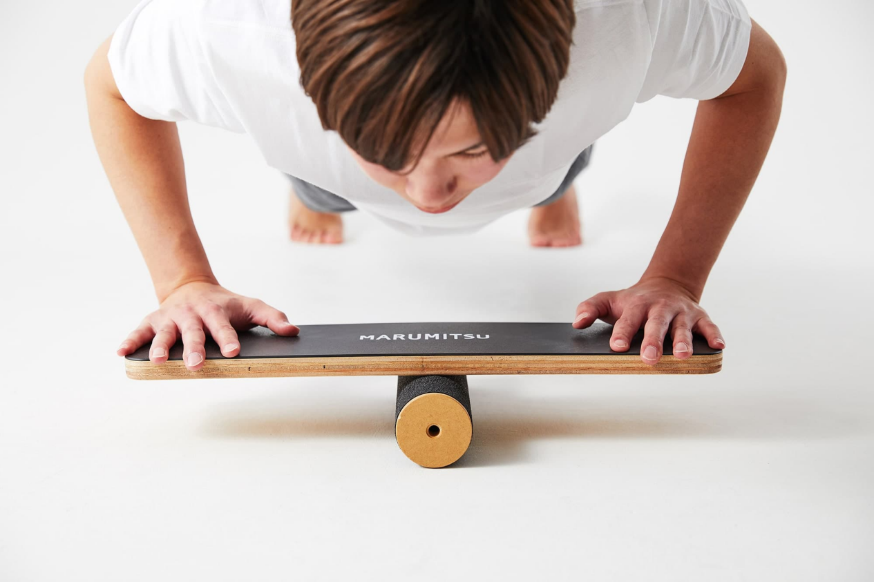 Man doing a push-up on a balance board.