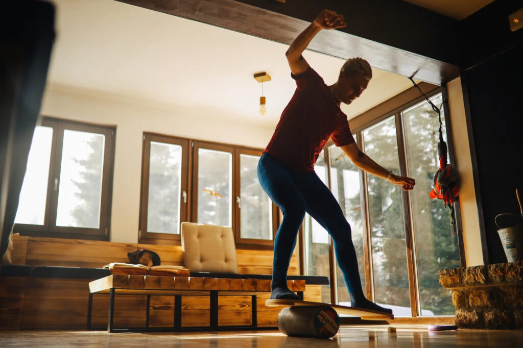 Woman exercising balance on a balance board at home.