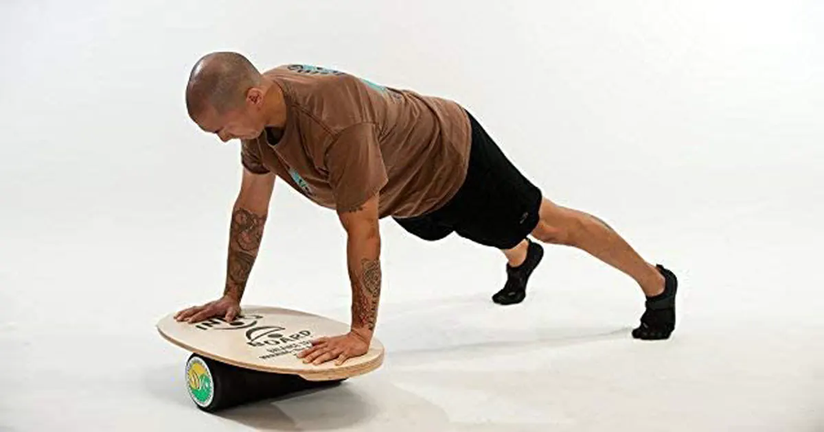 Man performing a push-up exercise on an INDO balance board for fitness training.