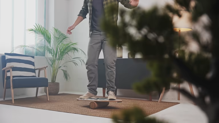 Man maintaining balance on a wooden balance board indoors, improving stability at home.